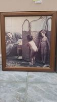 Frontal image showing the print titled "Before the Bath" featuring two children and a woman, framed in a brown wood frame.