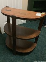 Front angled view of the wooden demilune wall table with water marks visible on the top surface.