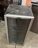 Front view of Danby wine fridge showing glass door, silver trim and dusty top