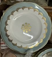Close-up of a large plate showing light blue rim and gold filigree snowflake pattern