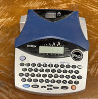 Clear top view of Brother P-Touch label maker showing keyboard, display screen, and label slot.