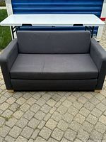 Front view of dark gray IKEA pull-out couch closed.