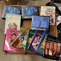 Top-down photo showing various TV series DVD box sets including multiple Golden Girls seasons, Matlock, Murphy Brown, The Affair Season One, and Fawlty Towers.