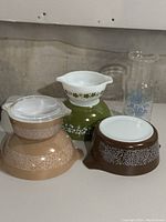 Photo of whole lot showing multiple Pyrex bowls in different colors and pitcher with floral patterns.