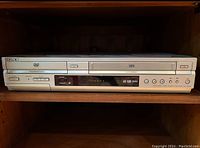 Front view of the Sony DVD/VCR combo unit showing the VCR tape slot, DVD tray, control buttons, and LED display.
