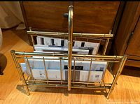 Brass magazine rack with bamboo-inspired design, shown containing magazines for scale but contents not included.
