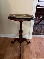 Full view of Queen Anne small wooden pedestal side table with brass gallery tray on top.
