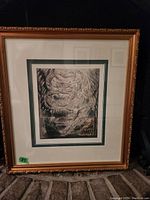 Full view of framed print artwork featuring abstract design in dark tones with gold frame and double mat.