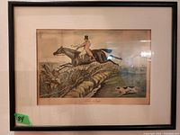 Framed print titled 'The Leap' showing a hunter on horseback jumping over a ditch with a dog running beside them.
