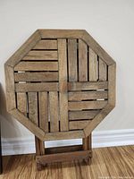 Front view of the octagonal wooden table top with foldable wooden base.