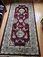 Photo of rectangular decorative office rug on wood floor showing pattern and colors.