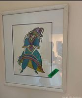 Framed print showing a figure dressed in a colorful, elaborate costume with floral elements