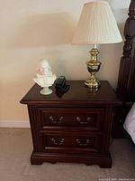 Single bed side table with decorative lamp and bust (contents not included) visible on top