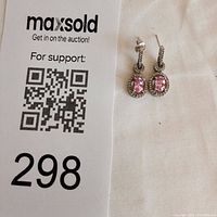 Front view of earrings next to lot number card