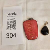 Photo showing both pendants side by side on a white background with a maxsold auction tag.