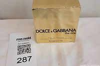 Front of gold box with Dolce & Gabbana The One branding and product size details.