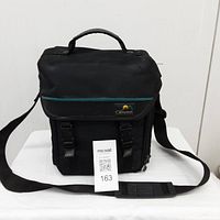 Black Sony branded carrying bag with shoulder strap standing upright on white surface