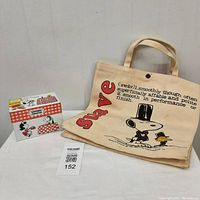 Overview of the vintage Snoopy recipe box and canvas bag together showing the bag's handles and the box's recipe label.
