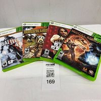 Four Xbox 360 game cases: Battlefield 4, Borderlands 2, Red Dead Redemption, and Mortal Kombat arranged side by side.