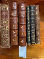 Full set of six collectible older books shown from front and spine views on wood surface.