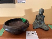 Overview of decorative bowl with chip and kneeling female sculpture