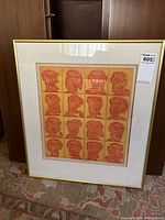 Front view of framed coloured etching showing the grid of abstract faces and overall presentation