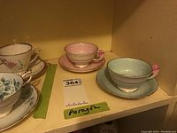 Two Paragon cups and saucers on shelf with reference sticker