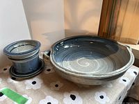 View of large two-handled bowl and smaller bowl with under plate, showing glazing and size comparison