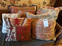 Photo of the full set of five decorative throw pillows with varied tapestry and floral patterns