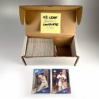 Overview photo of the open box with the complete set of 1993 Leaf Series 1 baseball cards, showing the thickness and condition of the cards inside the box along with two individual cards visible in front.