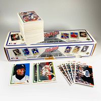 Photo showing the 1991 Upper Deck Baseball Complete Set box with a large stack of baseball cards and selected specialty cards laid out in front of the box including Rickey Henderson and Bo Jackson cards.