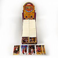 Full view of cardboard display box filled with loose cards plus five sample cards laid in front