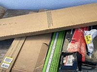 Various cardboard boxes, some with labels and packaging visible containing poles and parts