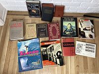 Overview image showing thirteen books arranged on floor, with visible titles including The Gulag Archipelago, Inferno, Game of Thrones Dothraki guide, and others.