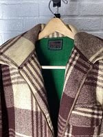 Close-up of collar, inside chest label, and green interior wool lining of the plaid Chippewa coat.
