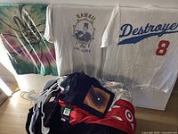 T-shirts including tie-dye peace sign, Hawaii Live Aloha, white Destroyer 8, plus black and red pants with Nike Target branding