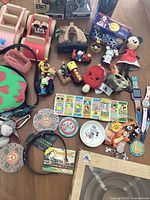 Overview of various Disney collectibles including figurines, wristwatches, keychains, pins, and small toys