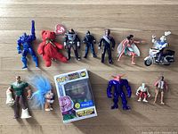 A collection of 13 various figures including Star Trek characters, Marvel and DC figures, a red Ty Beanie Baby bear, a Trolls figure, and a boxed Marvel Zombies Funko Pop! figure.