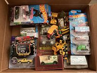 Full box view showing mixed loose and boxed vintage diecast vehicles including Hot Wheels, construction vehicles, and collectible cars.