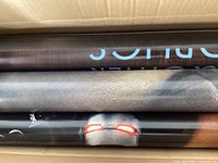 Close-up view of rolled double-sided movie posters showing part of the Iron Man 2 poster among others.