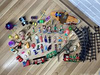 Wide view of all items showing train set, figurines, and accessories arranged on floor