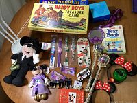 Full tabletop view of all Disney collectibles, games, watches, and plush dolls