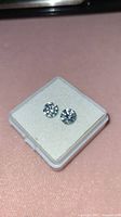 Two round diamonds on white foam pad, top view