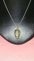 Photo of the lemon quartz pendant necklace displayed on black bust background from the front view showing the pendant shape and chain style.