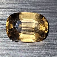 Close-up of the faceted whiskey quartz gemstone showing rich golden-brown color and detailed cut.
