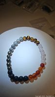 Bracelet laid flat showing the colors and types of the round 6mm mixed natural gemstone beads under bright light.