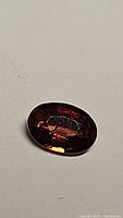 Photo of oval cut natural AAA Cambodian zircon gemstone showing deep orange fire and reflective facets