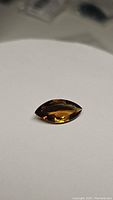 Close-up of 5.81ct natural Madeira citrine marquis cut gemstone showing deep cognac coloration and high clarity.