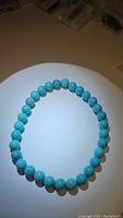 Photo showing round robin's egg blue turquoise beads bracelet laid flat, highlighting bead size and turquoise natural patterns.