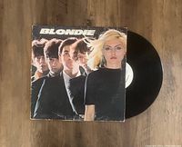 Photo shows Blondie LP vinyl record partially out of sleeve. Cover features Blondie band members portrait. Sleeve shows some edge wear.